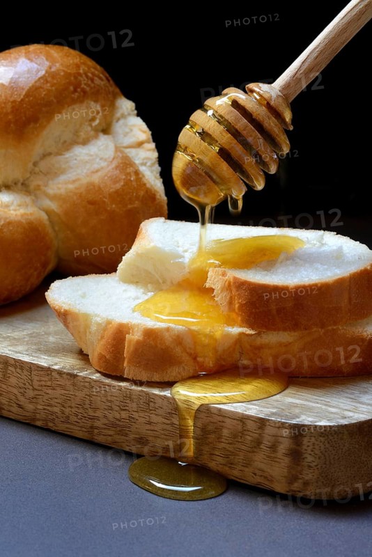 Bee honey dripping onto butter plait discs