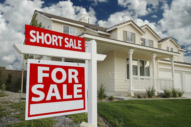 Short sale home for sale real estate sign and house