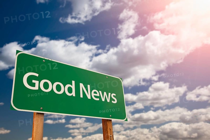 Good news green road sign against sky