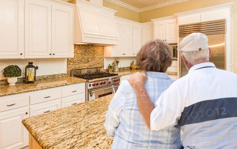 Happy senior couple looking over beautiful custom kitchen design