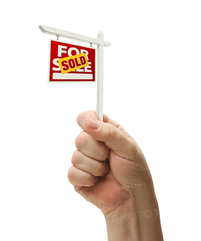 Sold for sale real estate sign in male fist isolated on a white background