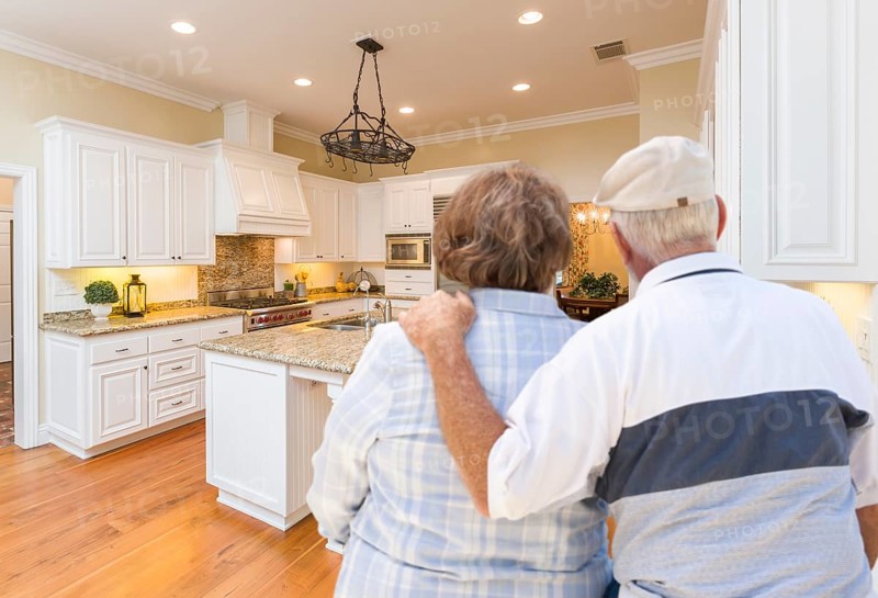 Happy senior couple looking over beautiful custom kitchen design