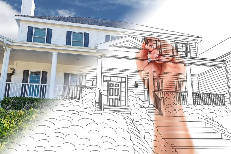 Male hand sketching with pencil the outline of a house with photo showing through