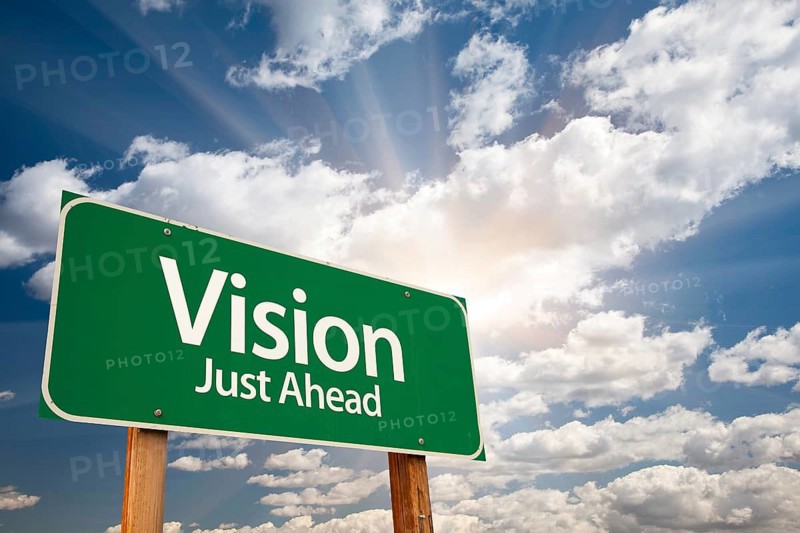 Vision just ahead green road sign with dramatic clouds