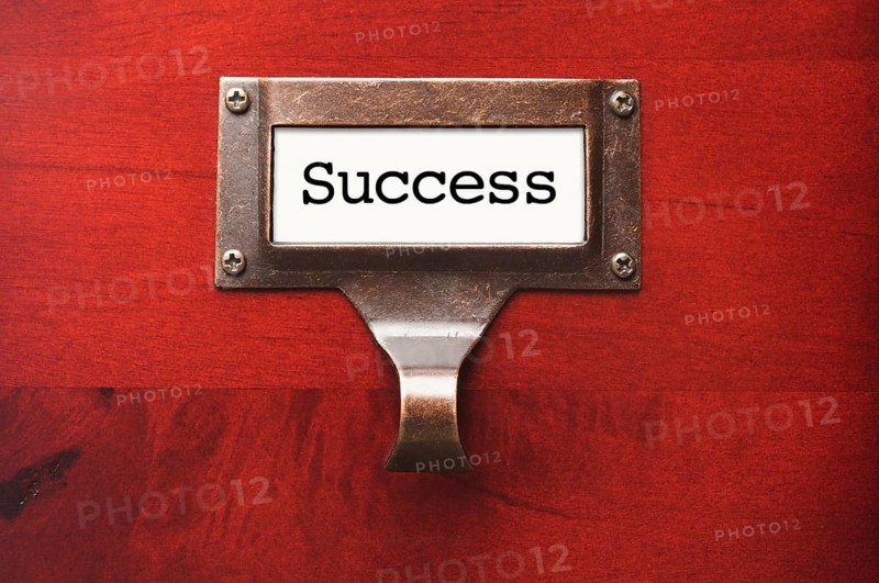 Lustrous wooden cabinet with success file label in dramatic light