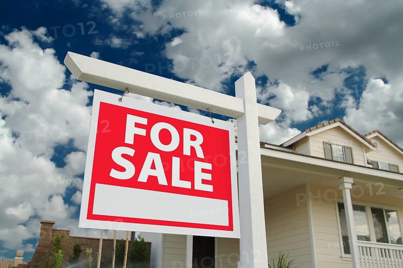 Home for sale sign in front of new house