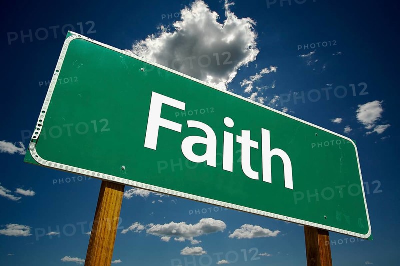 Faith road sign with dramatic clouds and sky
