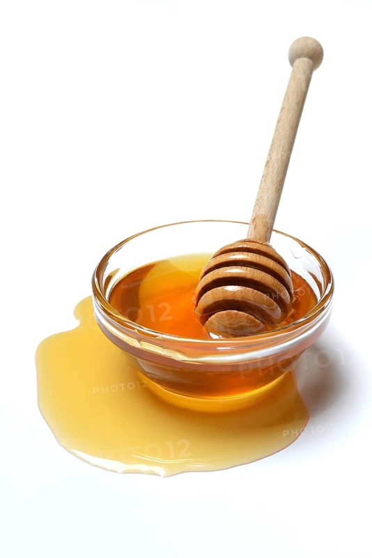 Bee honey with honey spoon in bowl