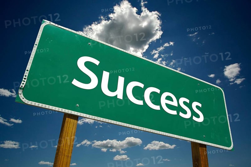 Success road sign with dramatic clouds and sky