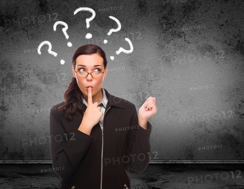 Question marks drawn above head of young adult woman in front of wall with copy space