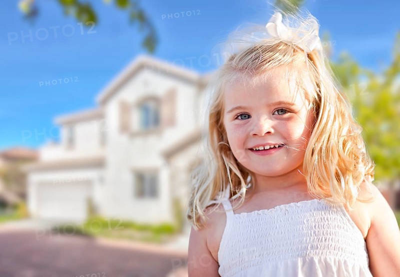 Cute smiling girl playing in front yard of house