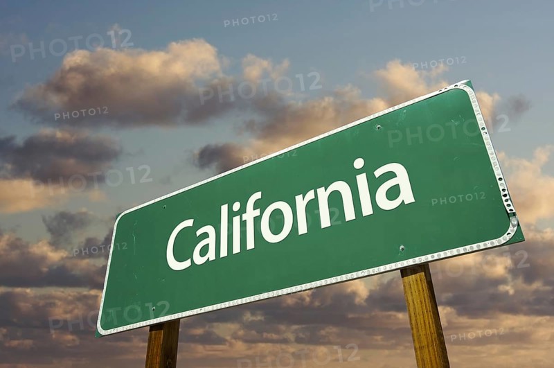 California green road sign with dramatic blue sky and clouds