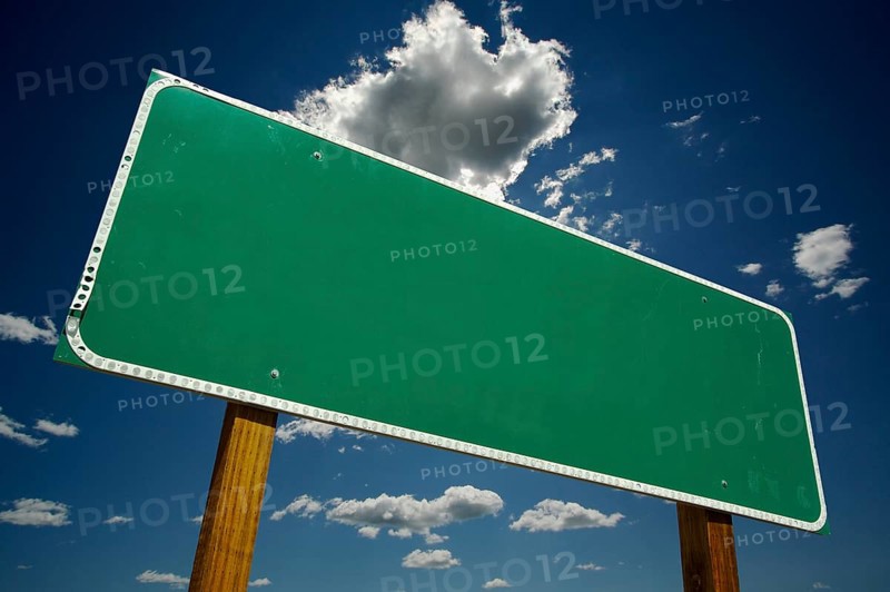 Blank green road sign on dramatic blue sky with clouds