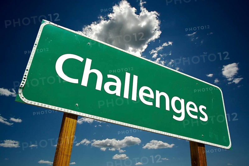 Challenges road sign with dramatic clouds and sky
