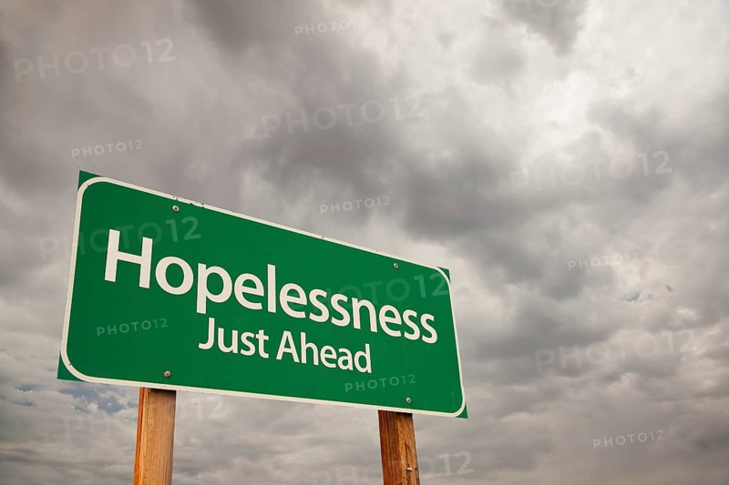 Hopelessness just ahead green road sign with dramatic storm clouds and sky