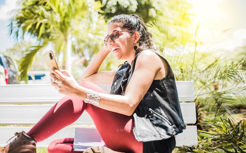 Girl sitting on a bench checking her cell phone
