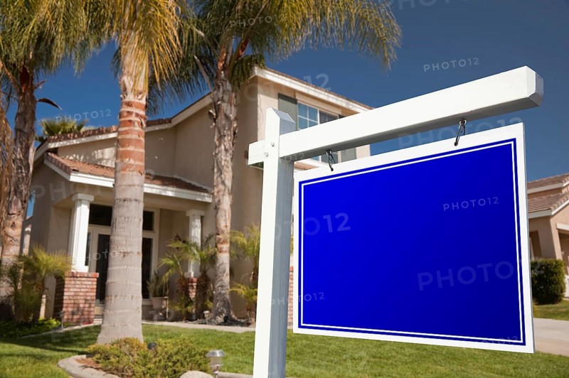 Blank real estate sign in front of house