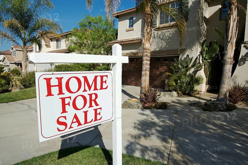 Home for sale sign in front of new house