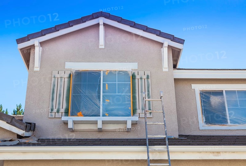 Construction ladder leaning up against A house ready for new paint