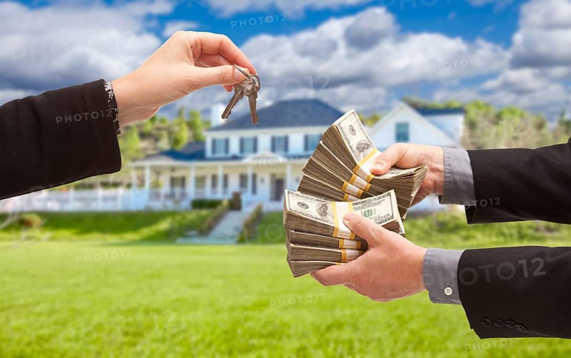 Man handing woman thousands of dollars for keys in front of house