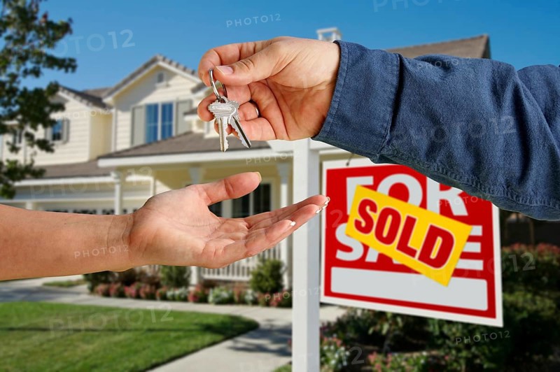 Handing over the house keys in front of a beautiful new home