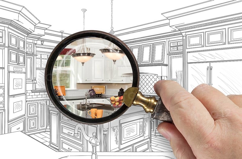 Hand holding magnifying glass revealing custom kitchen design drawing and photo combination