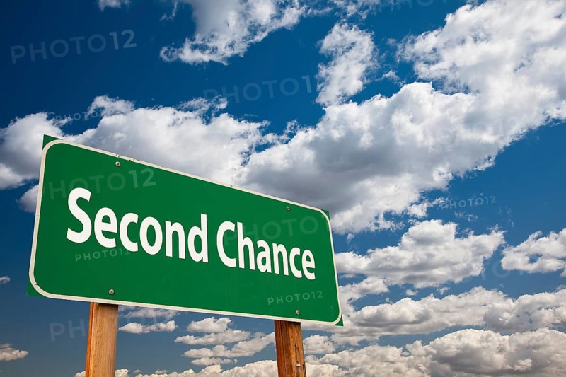 Second chance green road sign over clouds and sky