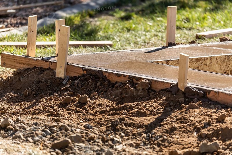 Fresh pool coping cement drying within wood framing
