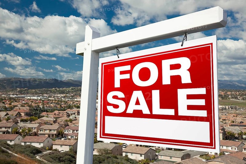 For sale real estate sign with elevated housing community view