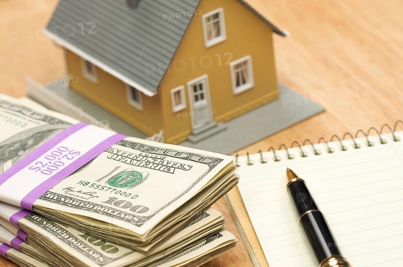 House and money with pad of paper and pen