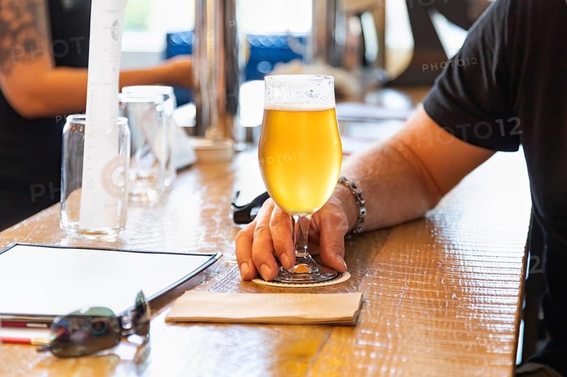 Man holding glass of micro brew beer at bar
