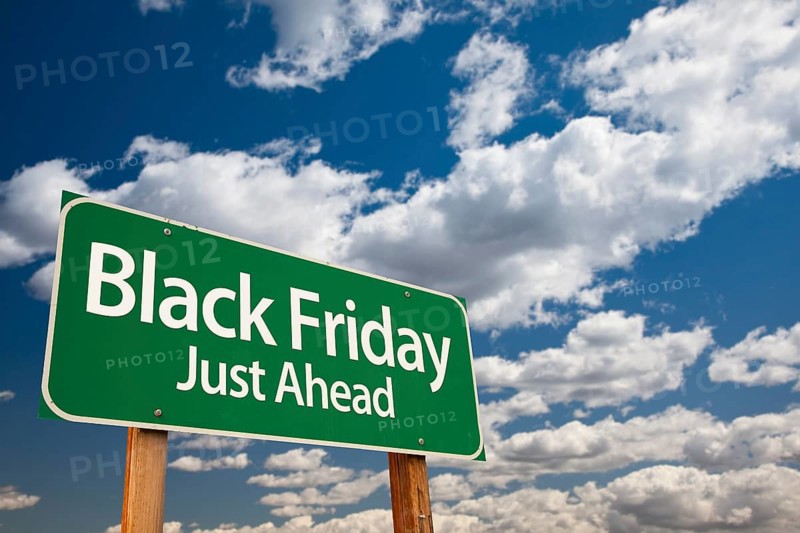 Black friday just ahead green road sign with dramatic clouds and sky