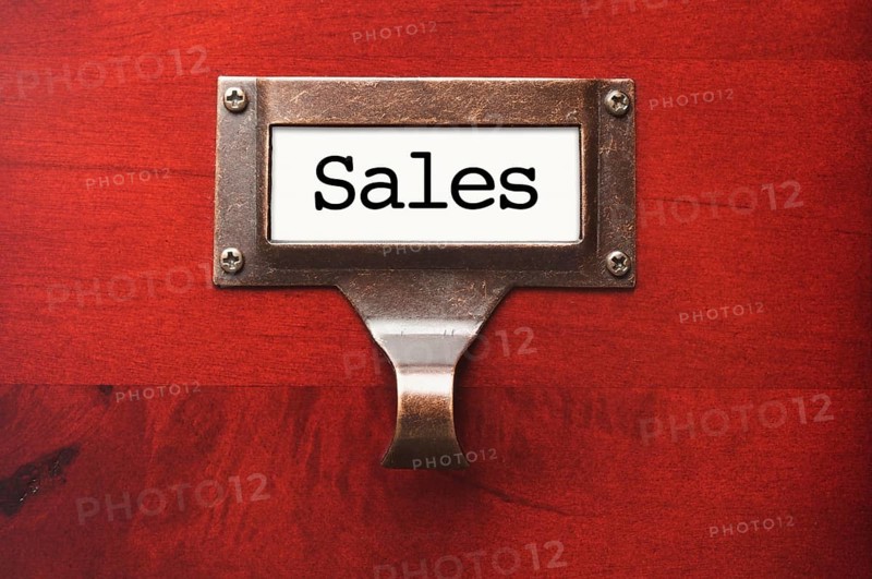 Lustrous wooden cabinet with sales file label in dramatic light