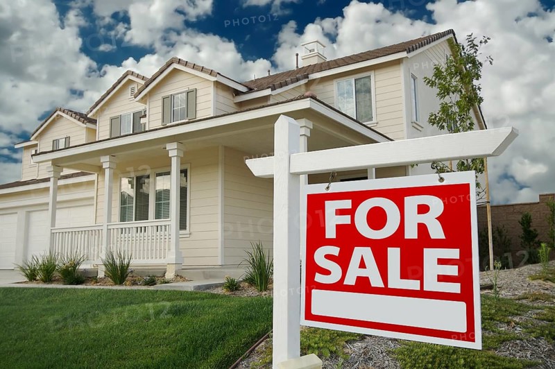 Home for sale real estate sign in front of new house