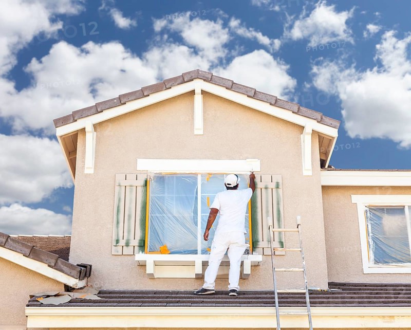 Busy house painter painting the trim and shutters of A home