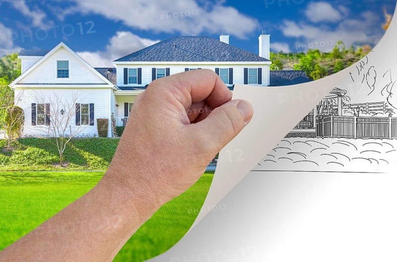 Male hand turning page of custom home photograph to drawing underneath