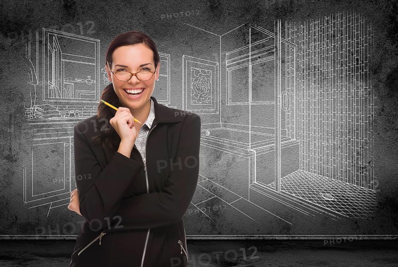 Young adult woman with pencil in front of bathroom design drawing on wall