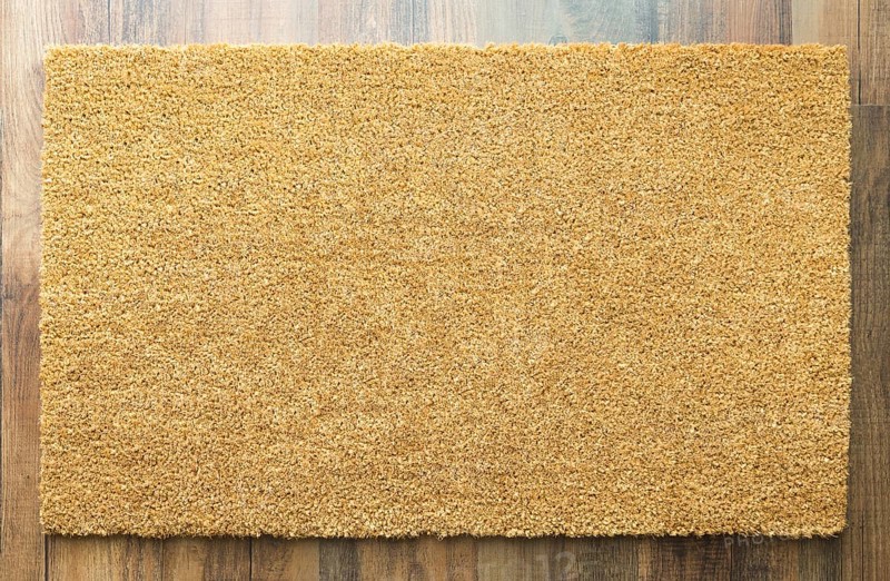 Blank welcome mat on wood floor background ready for your own text