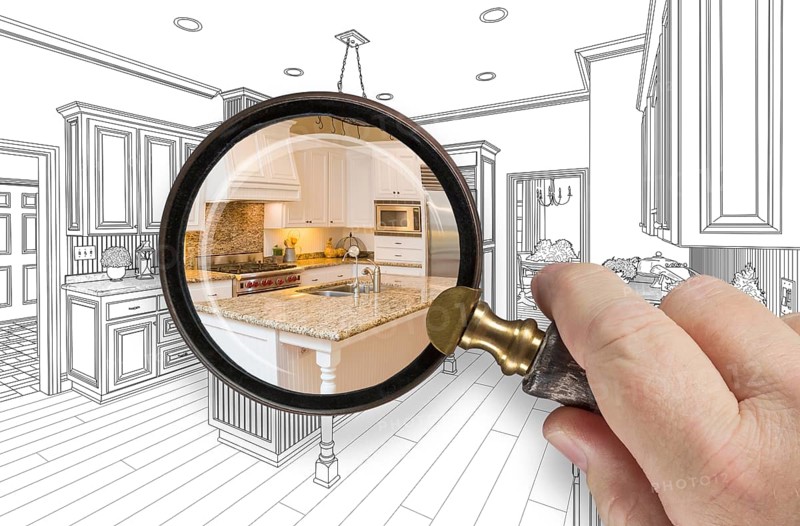 Hand holding magnifying glass revealing custom kitchen design drawing and photo combination