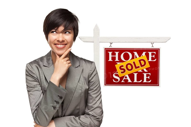 Ethnic woman in front of sold home for sale real estate sign isolated on a white background
