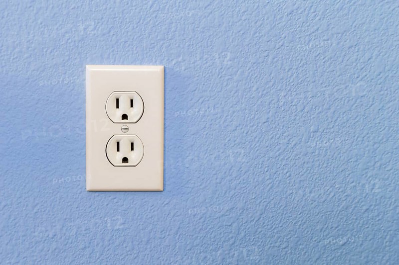 Electrical sockets in colorful blue wall of house