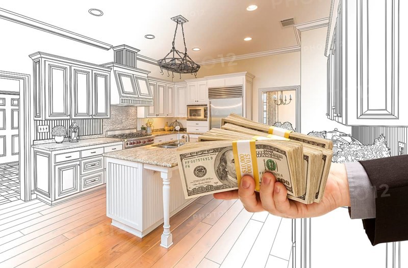 Hand handing stacks of money over custom kitchen design drawing and photo combination