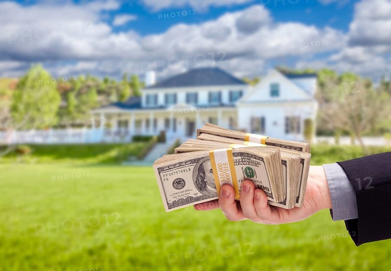 Handing over cash for house in front of beautiful new home