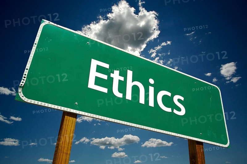 Ethics green road sign with dramatic blue sky and clouds