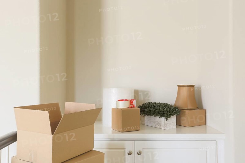 Variety of packed moving boxes and materials in empty room