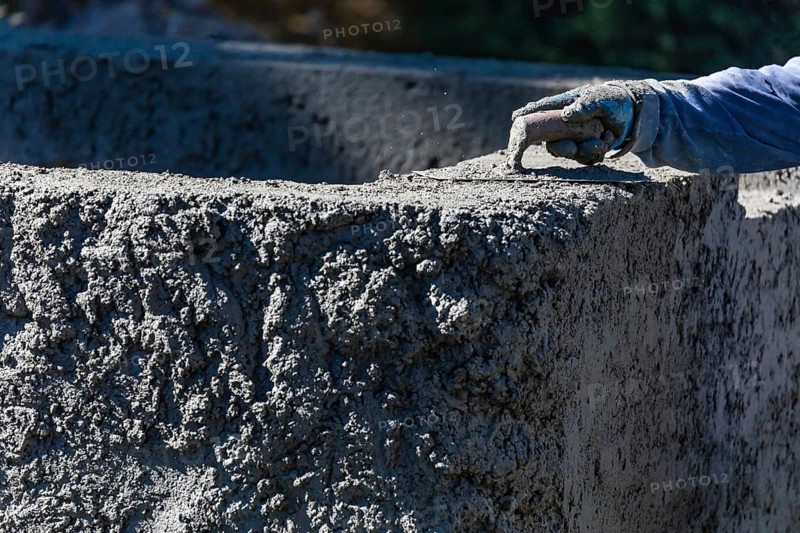 Pool construction worker working with A smoothing trowel on wet concrete