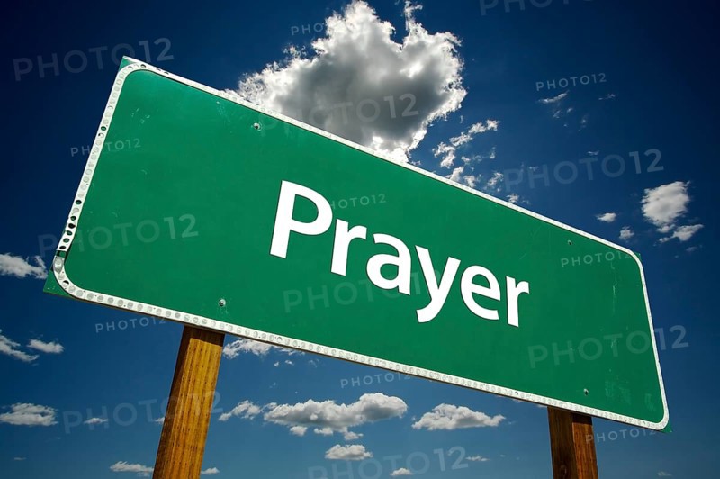 Prayer road sign with dramatic clouds and sky