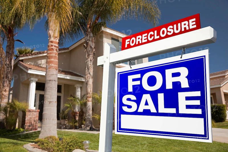 Foreclosure for sale real estate sign in front of house