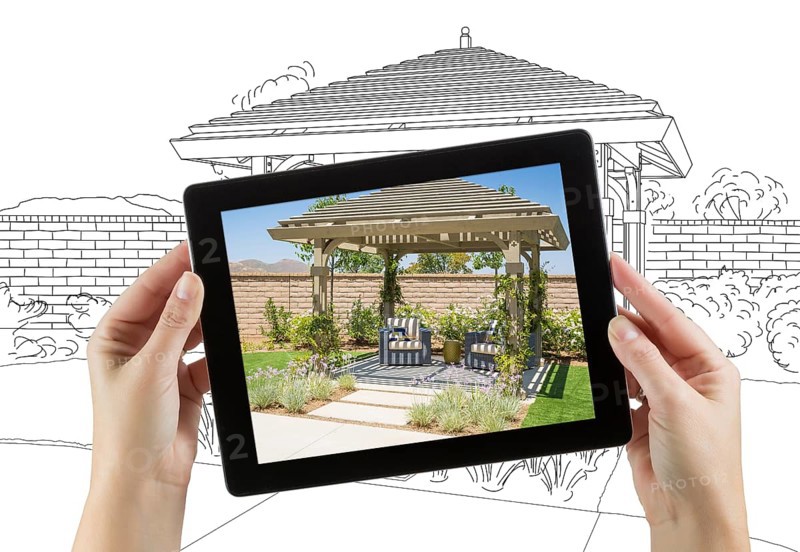 Female hands holding computer tablet with photo of pergola on screen