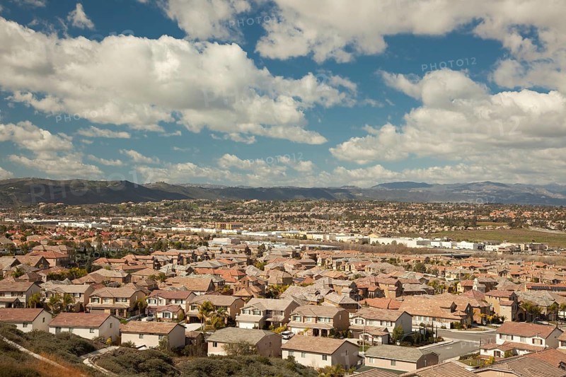 Elevated view of new contemporary suburban neighborhood and majestic clouds